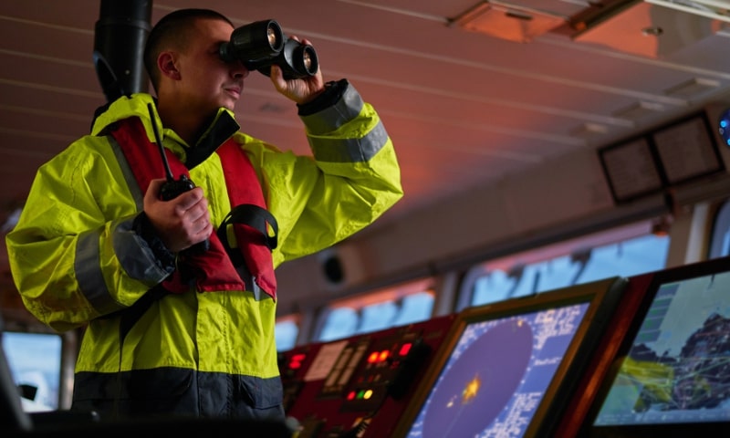 UK COC holder chief officer navigating through binoculars from deck cadet